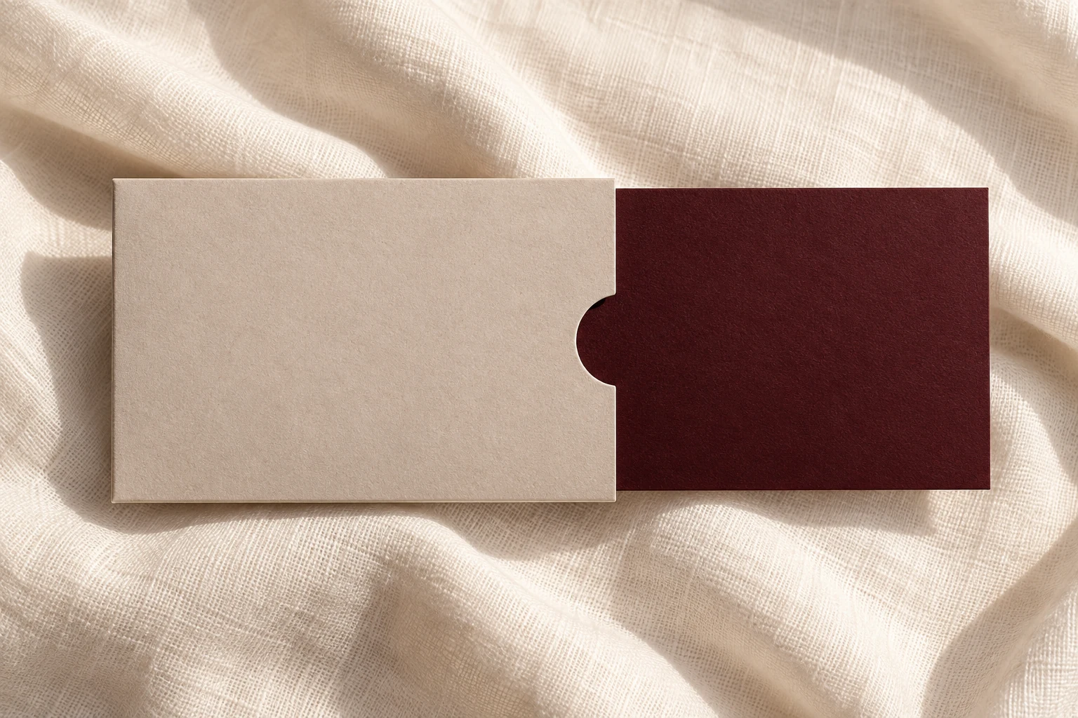 Conceptual wine gift card and oat sleeve on ivory fabric