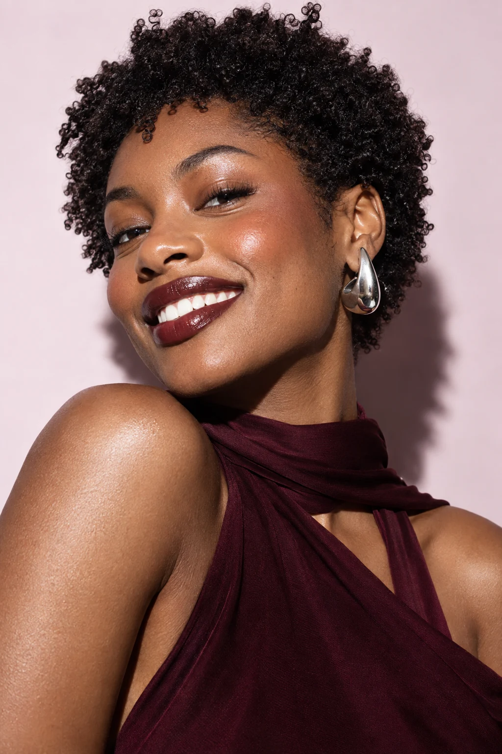 Conceptual editorial portrait of a young adult Black woman with curls and silver earrings